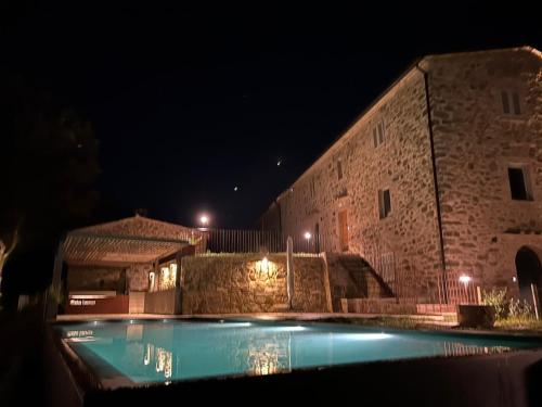 uma piscina em frente a um edifício à noite em Domus Eleiva Relais em Suvereto