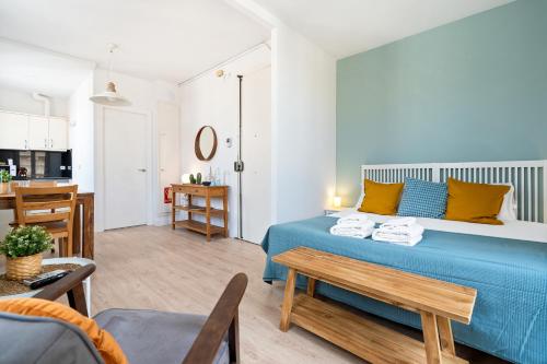 a bedroom with a blue bed and a kitchen at Lodging Apartments Beach Studio 41 in Barcelona