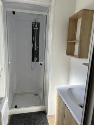 a glass shower in a bathroom with a sink at SOLEIL & PLAGE au CAMPING MAR ESTANG 4 ETOILES in Canet-en-Roussillon