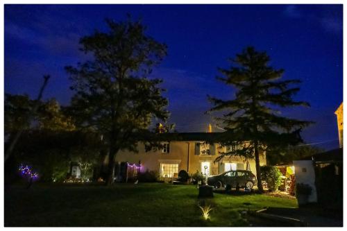 a house with a car parked in a yard at night at The blue lotus gite and spa in Le Langon
