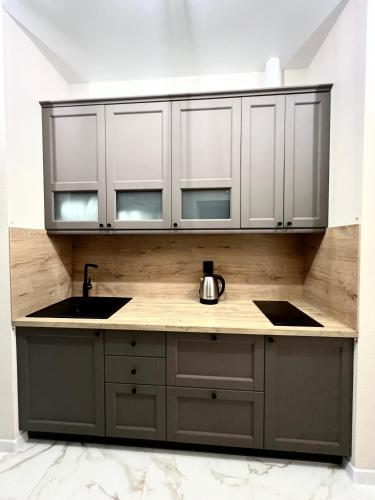 a kitchen with white cabinets and a sink at ЛЮКС на Собрной с 2-мя спальнями, Спасская50 in Mykolaiv