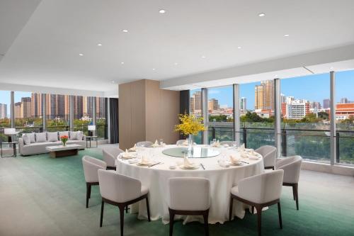 a dining room with a white table and chairs at Holiday Inn Quanzhou Donghai by IHG in Quanzhou