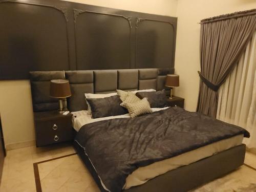 イスラマバードにあるedge villasの大型ベッド1台(黒いヘッドボード付)が備わるベッドルームです。