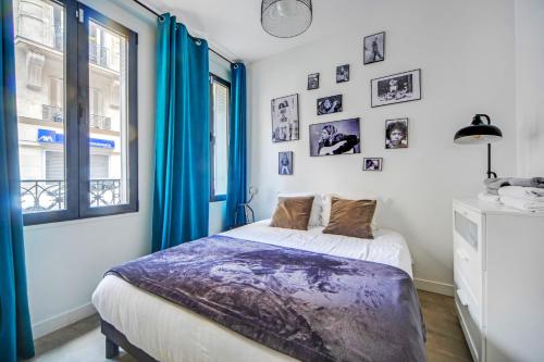 - une chambre avec un lit doté de rideaux bleus et d'une fenêtre dans l'établissement Large Flat Very Close to Montmartre, à Paris