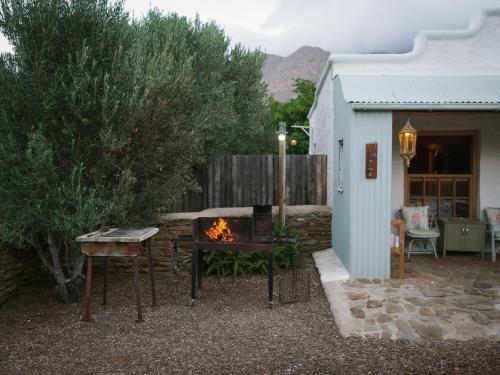 a fire pit in a yard next to a building at Olive Stone Farm Cottages in Montagu