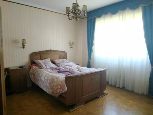 Ce lit se trouve dans une chambre dotée d'un rideau bleu et d'une fenêtre. dans l'établissement Grande maison vue sur mer, à Saint-Nazaire