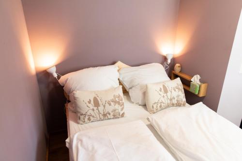 a bed with white sheets and pillows next to two lights at Altstadt Apartment am Dom Wetzlar, 1 Zi, Küche, Bad mit Parkplatz & WLAN in Wetzlar