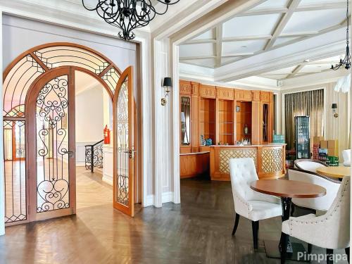 a living room with an open door with a table and chairs at Jomtien Beach, Pattaya - Seven Seas Côte d'Azur in Na Jomtien