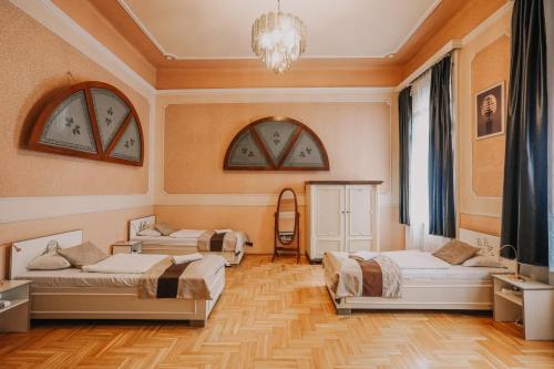 a bedroom with three beds and a chandelier at Unio Apartment in Budapest