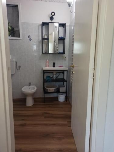 a bathroom with a sink and a toilet and a mirror at La Maisonette in Sori