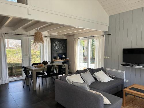 een woonkamer met een bank en een tafel bij Villa DUNE in Biscarrosse