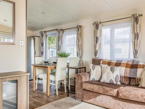 a living room with a couch and a table at Charming Chalet at Lakeside Park - Pass the Keys in Chichester