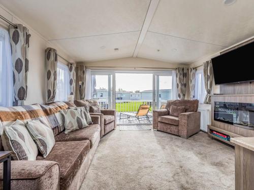 a living room with a couch and chairs and a television at Charming Chalet at Lakeside Park - Pass the Keys in Chichester