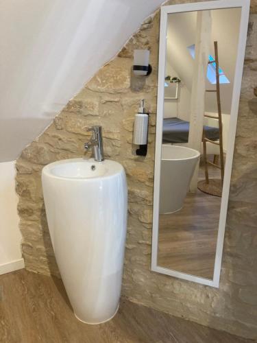 une salle de bain avec un lavabo et un miroir dans l'établissement L'étincelle, à Saint-Martin-des-Entrées