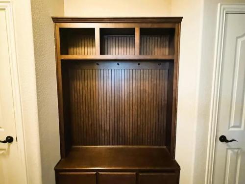 a wooden book shelf in the corner of a room at Luxurious 4br 3 baths office game room - 85 inch TV - Close to fishing boating and outdoors activities in Wylie