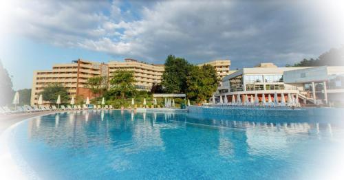 una gran piscina de agua azul frente a los edificios en Hissar Spa Hotel, en Hisarya