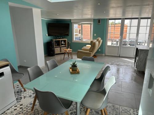 une salle à manger avec une table et des chaises bleues dans l'établissement Gîte accès direct à la plage du DDAY, à Saint-Marcouf