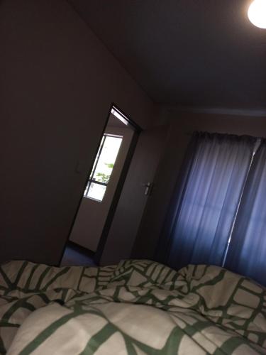 ein kleines Schlafzimmer mit einem Bett und einem Fenster in der Unterkunft Home in pretoria in Pretoria