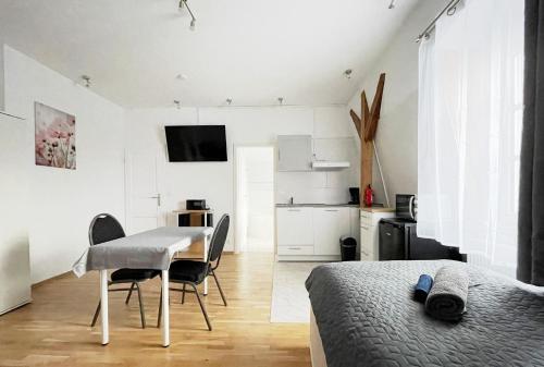 a bedroom with a table and chairs and a kitchen at Apartments-Alt-Marzahn in Berlin