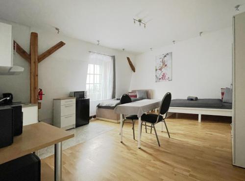 a room with a table and chairs and a bed at Apartments-Alt-Marzahn in Berlin