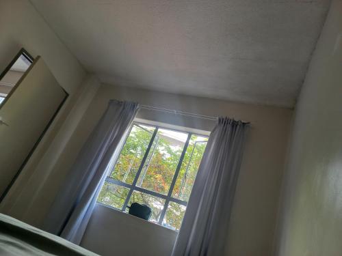 ein Fenster in einem Zimmer mit einem Vorhang in der Unterkunft Home in pretoria in Pretoria
