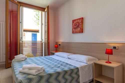 a bedroom with a large bed and a window at Appartmento S3M in Isola Albarella