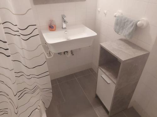 uma casa de banho branca com um lavatório e um balcão em Sunny&Cozy - Maisonette Apartment in See Nähe em Feldkirchen in Kärnten