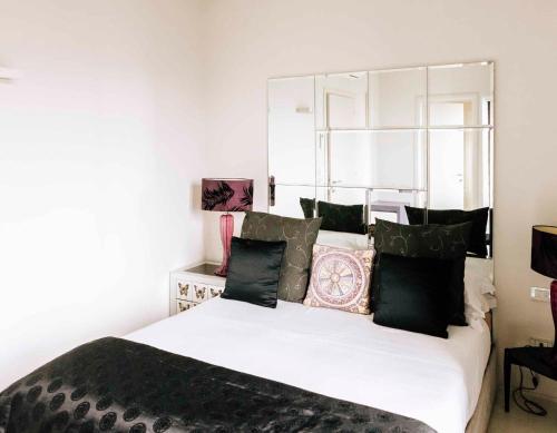 a bedroom with a large white bed with black pillows at Tenuta Moncarlino in Morsasco