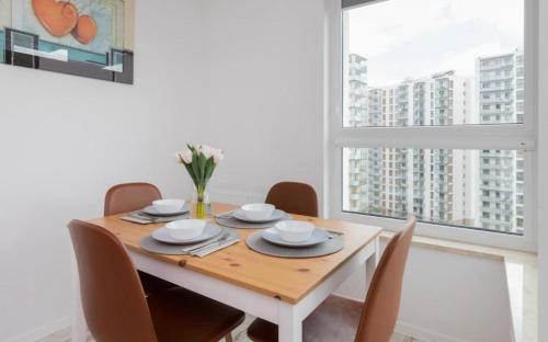 a dining room with a table and chairs and a window at Letnica Gdańsk in Gdańsk