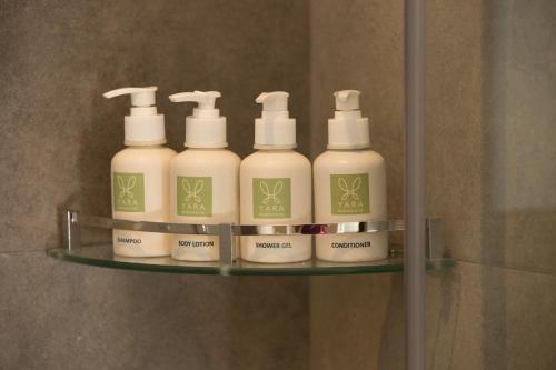four bottles of lotion on a shelf in a bathroom at Yara Nuwara Eliya in Nuwara Eliya