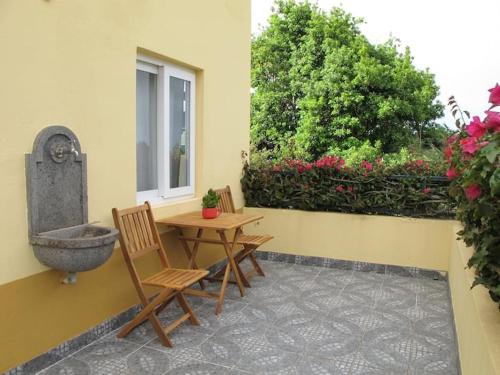 a patio with two chairs and a table and a fountain at GuestReady - Casa do Bisbis in Lanceiros
