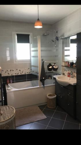 une salle de bain avec une baignoire et un lavabo dans l'établissement Maison a partager avec l'hôte, à Digne-Les-Bains
