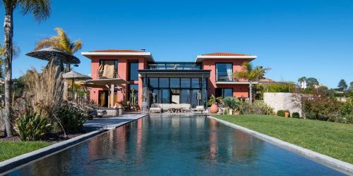 une maison avec une piscine devant une maison dans l'établissement Villa de luxe piscine vue mer, à Nice