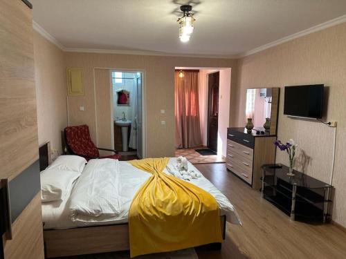 a bedroom with a bed with a yellow blanket on it at Sweet home kutaisi in Kutaisi
