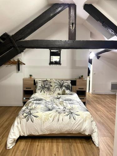 a bedroom with a large bed in a loft at Les Loges de la Commanderie ! in Coulommiers