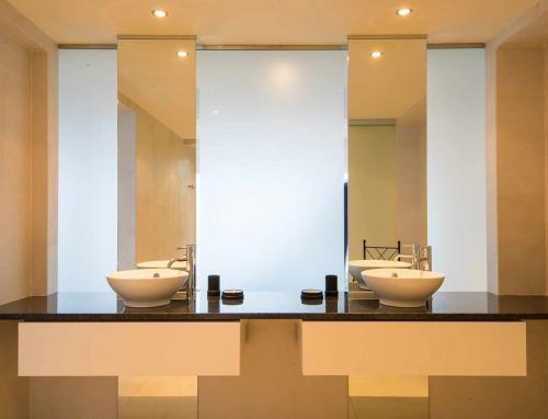 a bathroom with two sinks and a large mirror at Zula House - Stunning designer villa in spectacular location in Caniço