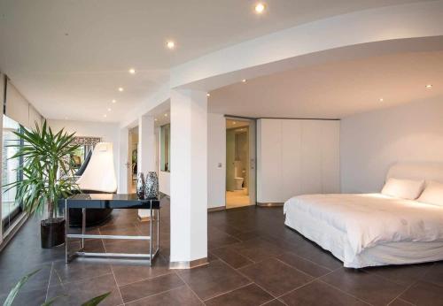 1 dormitorio con cama y escritorio. en Zula House - Stunning designer villa in spectacular location, en Caniço