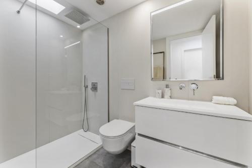 a white bathroom with a toilet and a shower at Casa Beyel La Concha in Playa Honda