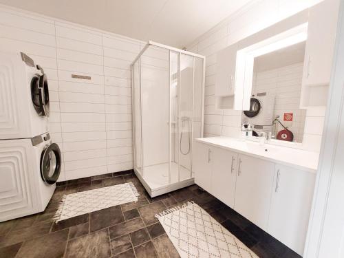 uma casa de banho branca com um lavatório e um frigorífico em Destination Senja - Skaland em Skaland