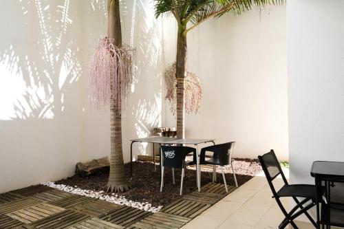 een eetkamer met een tafel en 2 palmbomen bij GuestReady - Charming Caniço Retreat in Caniço