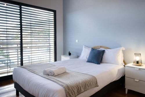 1 dormitorio con 1 cama blanca grande y ventana en GuestReady - Charming Caniço Retreat en Caniço