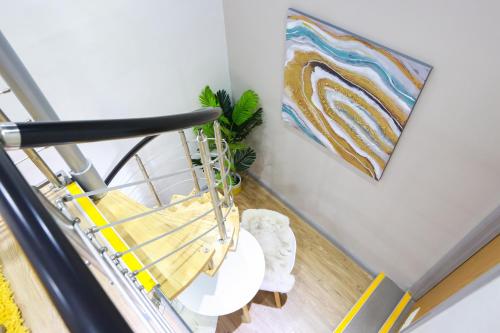 a staircase with a chair and a painting on the wall at E101 Urban chic loft in Coventry