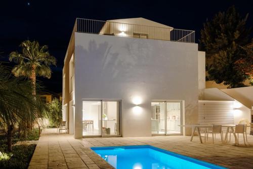 a white house with a swimming pool in front of it at GuestReady - A delightful stay in Porto Santo in Porto Santo