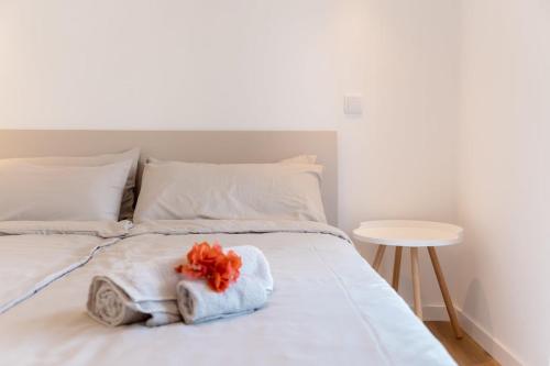 a white bed with towels on it with a table at GuestReady - A delightful stay in Porto Santo in Campo de Baixo