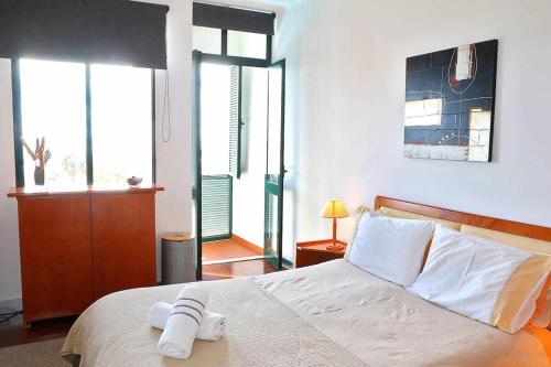 フンシャルにあるVarandas do Funchalのベッドルーム1室(ベッド1台、タオル2枚付)