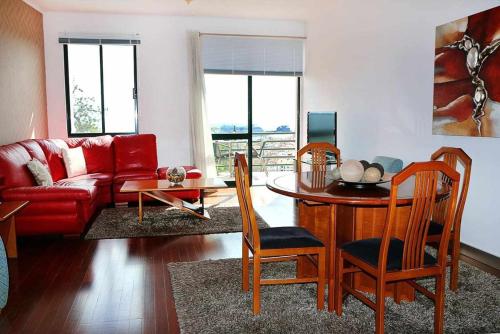 フンシャルにあるVarandas do Funchalのリビングルーム(赤いソファ、テーブル付)