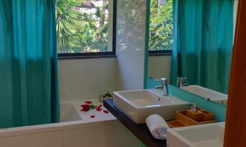 a bathroom with a sink and a tub and a mirror at Condomínio Zen Pearl-Luxury com piscina in Funchal