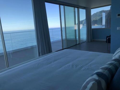 a bedroom with a bed with a view of the ocean at Casa Del Mar - Vistas Maravilhosas do Mar e Piscina in Ponta Delgada