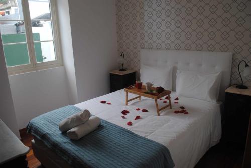 een slaapkamer met een bed met rozen erop bij Vila Rosa - Renovated House Overlooking The Sea in Funchal