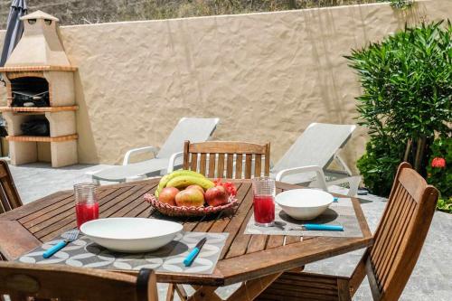 Una mesa de madera con un bol de fruta encima. en GuestReady - Windmill House, en Pontinhas